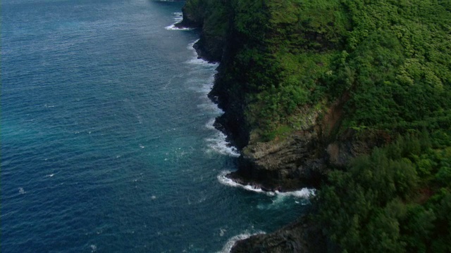 夏威夷考艾岛霍诺奥纳帕利自然保护区郁郁葱葱的海岸岩层鸟瞰图。视频素材