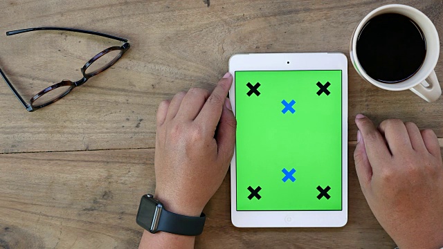 上图为使用绿色屏幕的数字平板电脑视频素材