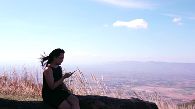 商务女性在山顶用智能手机拍照视频素材