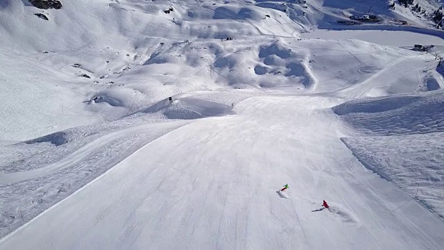 寒假，4k鸟瞰图两名滑雪者在宽阔的滑雪坡上滑雪视频素材