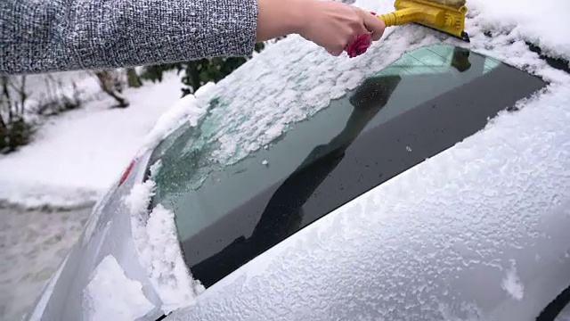 女人在刮车上的雪视频素材