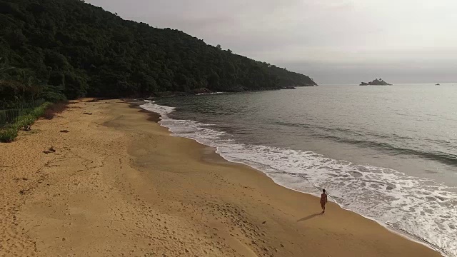 一名年轻女子在托克-托克佩基诺海滩散步的鸟瞰图视频素材