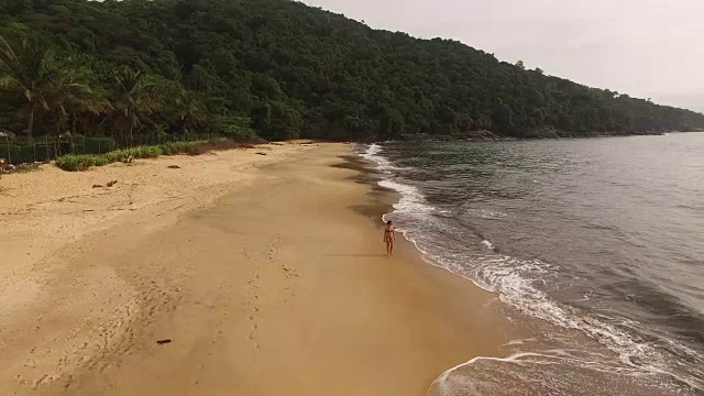 一名年轻女子在托克-托克佩基诺海滩散步的鸟瞰图视频素材