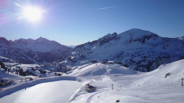 4k空中滑雪区阳光充足的冬季山脉视频素材