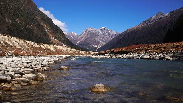 在拉冲，天气晴朗，从冰川融化的河流在山上观赏景观视频素材