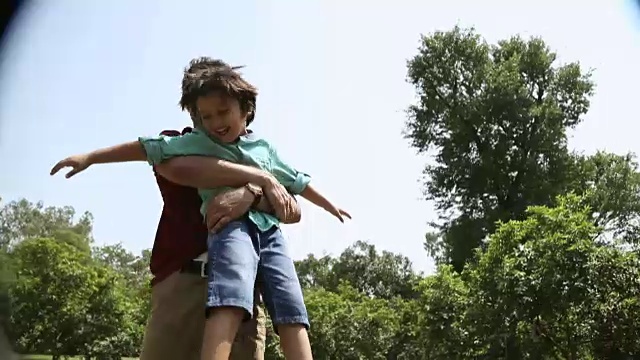 一名成年男子和儿子在印度德里的公园里玩耍视频素材