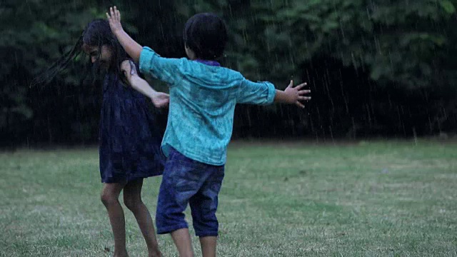 男孩和女孩在雨中享受，德里，印度视频素材