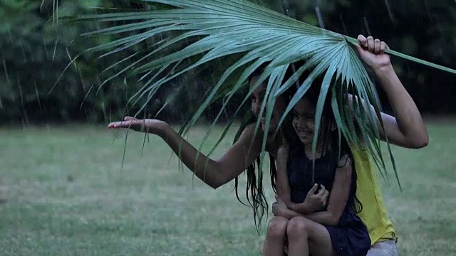 印度德里，年轻女子和女儿在雨中沐浴视频素材