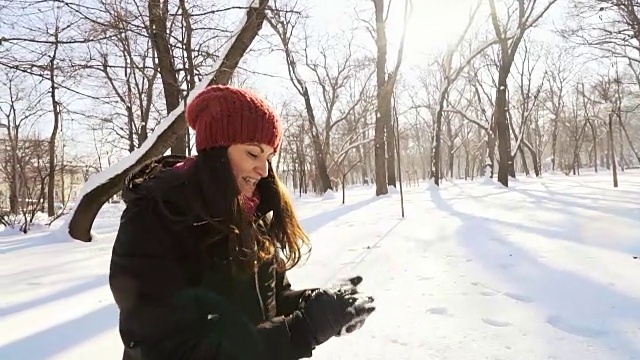 快乐的年轻女子玩和做雪球。视频素材