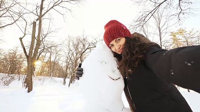 快乐的女人和雪人自拍。视频素材