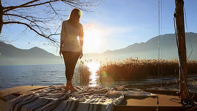 年轻女子在湖边做瑜伽视频素材