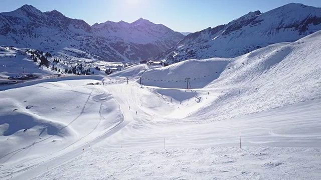 寒假，无人机拍摄一对夫妇在滑雪坡上滑雪视频素材