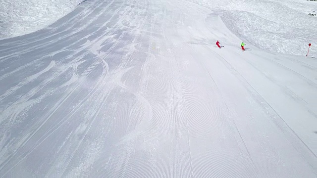 寒假，鸟瞰两个滑雪者在宽阔的滑雪坡上视频素材