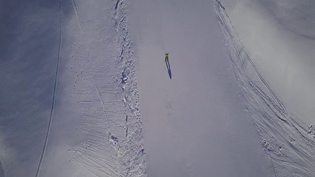 寒假，俯视图在滑雪斜坡上与无人机跟随滑雪者视频素材