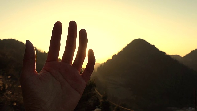 夕阳下透过手指的阳光视频素材