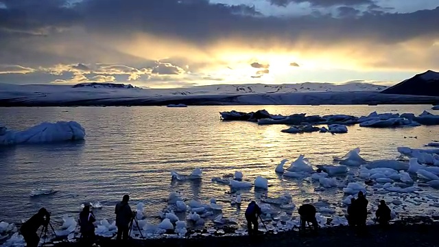 日落时分，一群人在Jokulsarlon泻湖的岸边。冰岛。视频素材