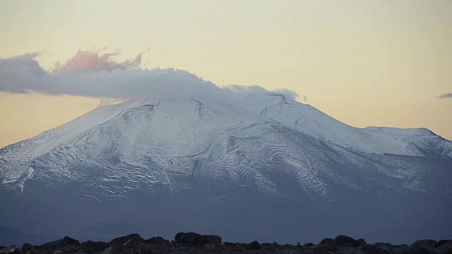 在阿塔卡马沙漠，低云在雪山上移动的时间流逝视频下载