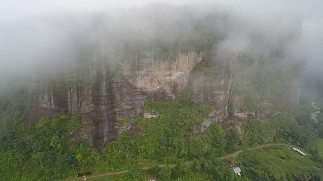 飞在美丽的山谷上空的云朵上，朝向瀑布和巨大的花岗岩视频素材