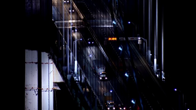 近距离拍摄的交通沿着维拉萨诺海峡大桥在纽约市的夜晚。视频素材