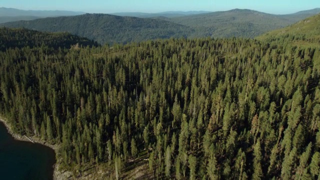 翱翔在加州拉森国家森林的Juniper湖的蓝山水域和柔和的绿色山峰之上。视频素材