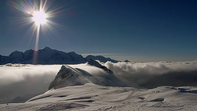 一个逆温云移动在一个积雪的山脊和角Platé的山峰在远处视频素材