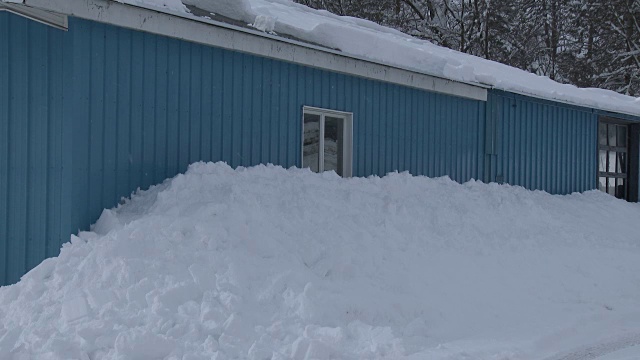 一幢建筑物的侧面堆积着厚厚的积雪视频素材