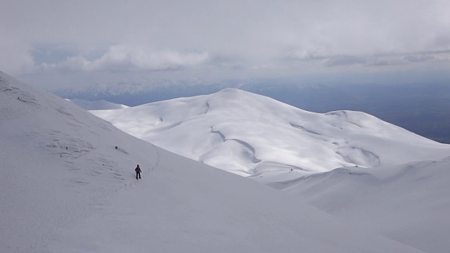 一位女攀登者正在一座山峰的顶峰上行走视频下载