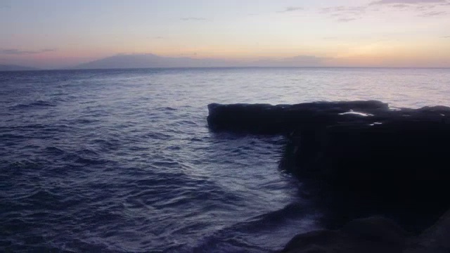 海滩上的日落，前景是巨大的岩石视频素材