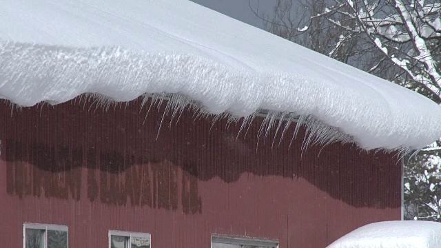 非常深的雪，冰柱悬挂在屋顶-暴风雪视频素材