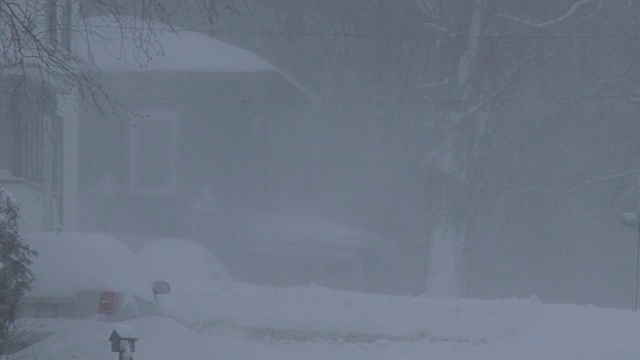 在暴风雪，大雪，白茫茫的条件下使用吹雪机的房主视频素材