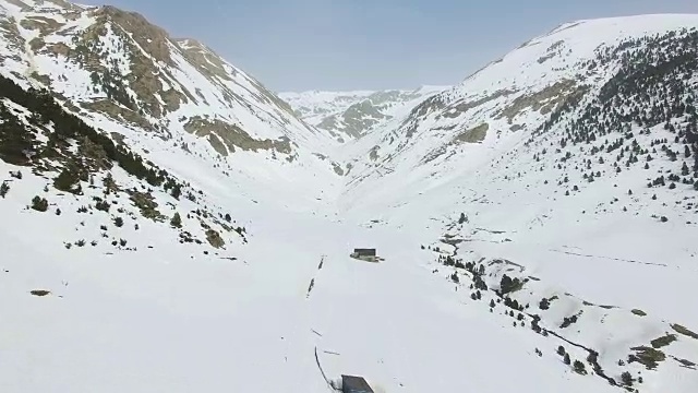 无人机拍摄的航拍镜头拍摄了美丽的安道尔雪景，与蜿蜒的河流在雪谷中流淌形成了很好的对比。视频素材