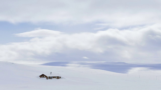 挪威哈当厄河的雪景中，云朵漂浮在一间小屋上方视频素材