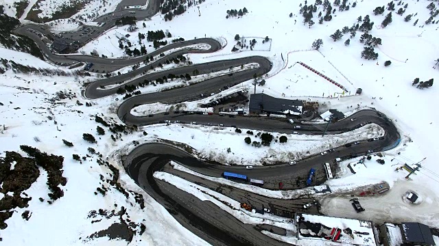 无人机在比利牛斯山脉上空拍摄的航拍镜头，上面有雪景和美丽的曲线，汽车在比利牛斯山脉上行驶。4 k UHD。视频素材