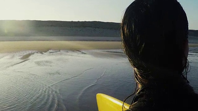 在法国南部大西洋海岸，女性冲浪者带着冲浪板走向海滩。视频素材