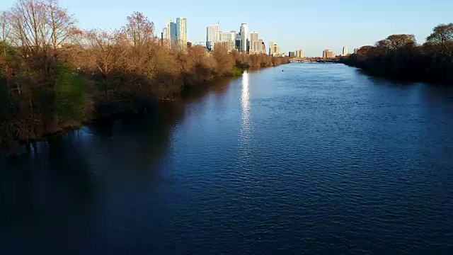 在奥斯汀镇湖在德克萨斯州航空深蓝的水沿着市中心天际线和皮划艇享受水视频素材