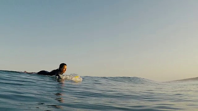 美丽的女性冲浪者与冲浪板在冲浪休息在荒芜的沙滩在大西洋海岸在法国南部。视频素材