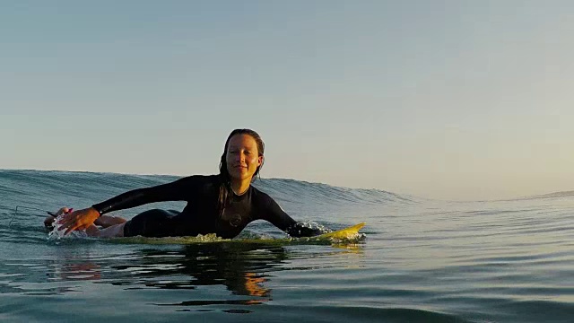 美丽的女性冲浪者在日落与冲浪板在荒凉的沙滩在法国南部大西洋海岸。视频素材