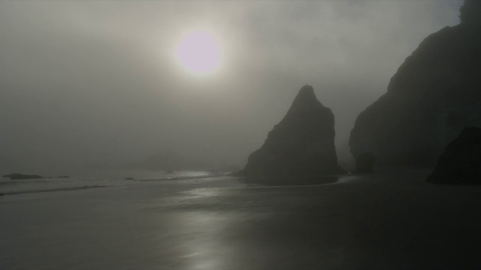 广角拍摄雾的剪影在海洋和海滩上的岩石形成时，海浪冲在日落，俄勒冈州视频素材