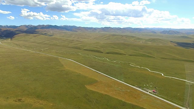 航拍的道路延伸到遥远的地平线上的草原，中国甘肃。视频素材