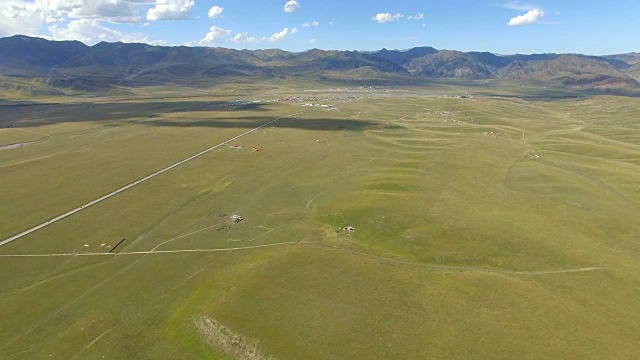 航拍的道路延伸到遥远的地平线上的草原，中国甘肃。视频素材