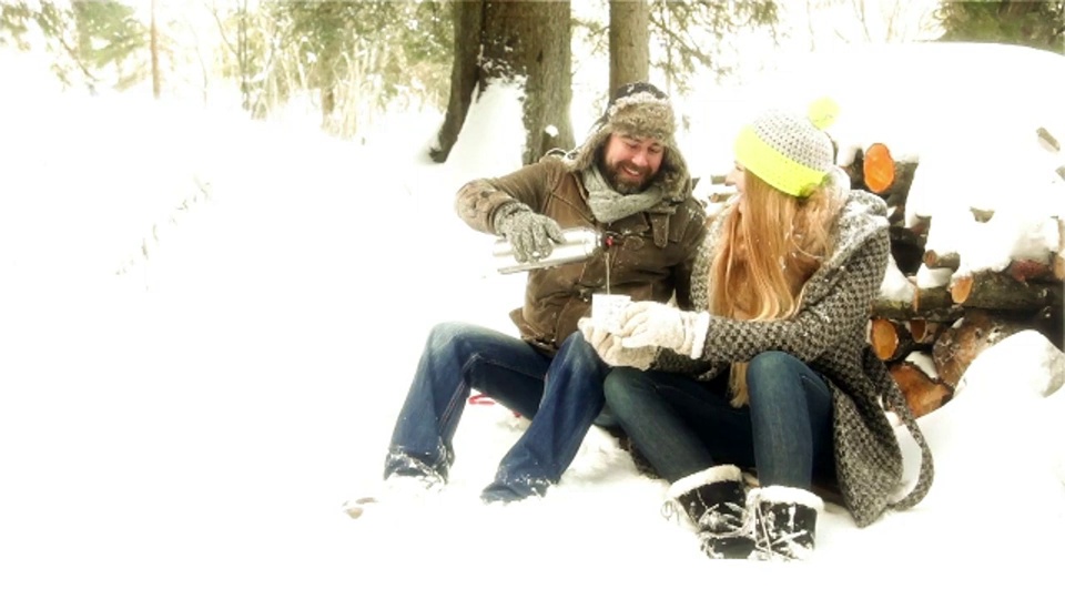 德国巴伐利亚，一对年轻夫妇正在白雪皑皑的风景中休息视频素材