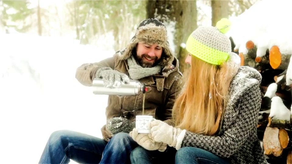 德国巴伐利亚，一对年轻夫妇正在白雪皑皑的风景中休息视频素材