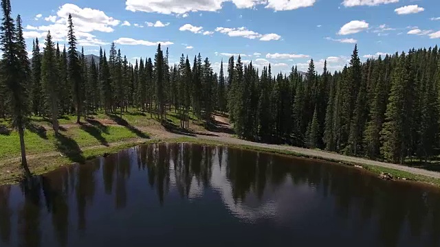 飞越划船显示在树，落基山脉揭示秋天的颜色湖反射，Off road, rzr野生动物，树叶短空中，4K，股票视频销售-无人机发现-无人机航拍视图视频素材