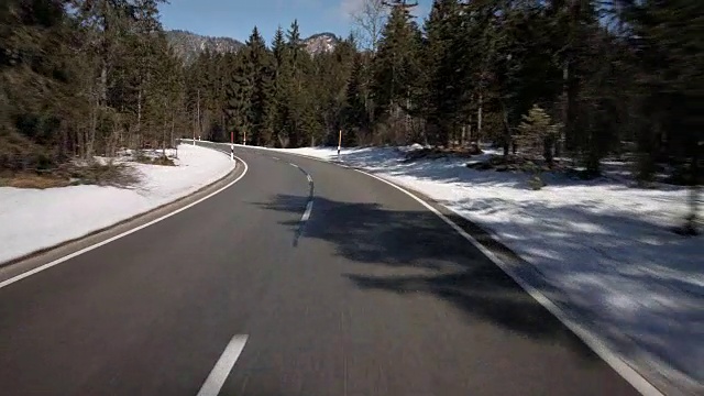 汽车背景/工艺板的司机POV(观点)，而驾驶在奥地利的乡村道路在阿尔卑斯高地在一个美好的阳光明媚的冬天/车载装配摄像机拍摄视频素材