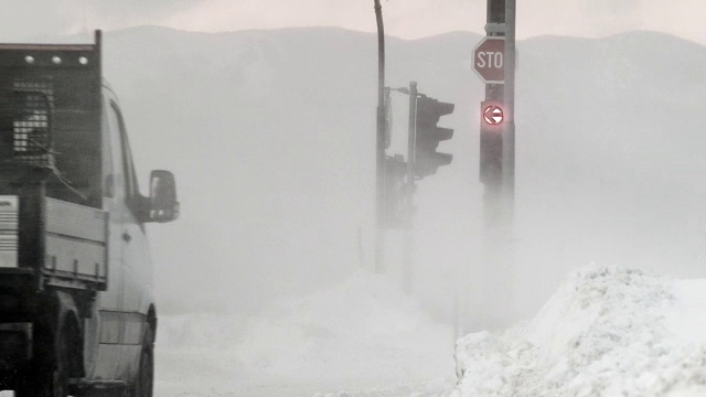 汽车在暴风雪中穿过十字路口视频素材