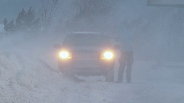 一个男人在暴风雪中清洗他的汽车视频素材