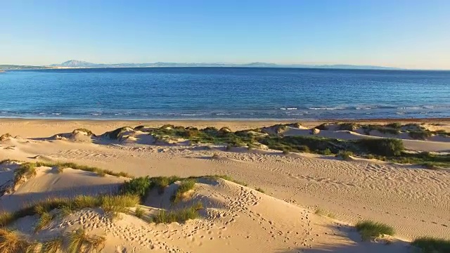 一个大沙丘的鸟瞰图与脚印和海洋和非洲海岸后面视频素材