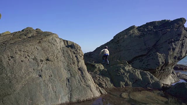 小男孩探索海岸岩石视频素材