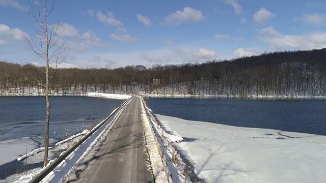 4k无人机在冰雪覆盖的冬季道路上空的鸟瞰图视频素材