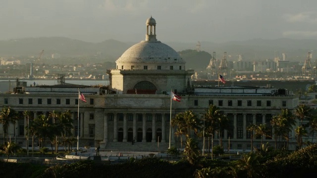 WS AERIAL POV波多黎各国会大厦，旗帜挥舞在前景/老圣胡安，波多黎各，圣胡安，美国视频素材